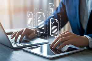 © Din Nasahrudin - stock.adobe.com Laptop mit zwei Händen und Check-Icons